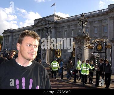 Vor dem Buckingham Palace in London steht Jason Hatch, der Protestierende der 4. Justiz der Väter. Herr Hatch wurde heute auf Kaution von der Polizeiwache Charing Cross freigelassen, nachdem er gestern im Palast als Batman gekleidet protestiert hatte. Stockfoto