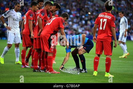 Fußball - UEFA Super Cup 2014 - Sevilla / Real Madrid - Cardiff City Stadium. Schiedsrichter Mark Clattenburg sprüht während des UEFA-Super-Cup-Finales im Cardiff City Stadium in Cardiff ein paar Spritzer auf dem Spielfeld. Stockfoto