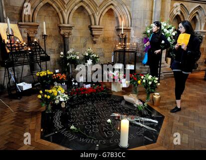 Nach einem Gottesdienst anlässlich des 25. Jahrestages des Untergangs des Marchioness-Flussschiffs auf der Themse in London schauen sich die Menschen die Blumen an, die auf dem Denkmal in der Southwark Cathedral, Southwark, im Süden Londons, zurückgelassen wurden, nachdem 51 Menschen starben, als das Schiff vom Bagger Bowbelle Thames getroffen wurde. Stockfoto