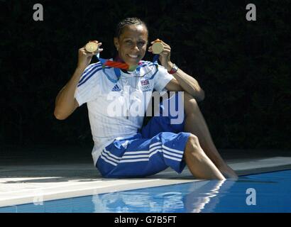 Die britische Doppelgoldmedaillengewinnerin Kelly Holmes feiert mit den Medaillen, die sie während der Olympischen Spiele in Athen für die 800 und 1500 Meter gewonnen hat. Stockfoto