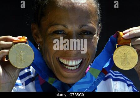 Die britische Doppelgoldmedaillengewinnerin Kelly Holmes feiert mit den Medaillen, die sie für die 800 und 1500 Meter in Athen, Griechenland, gewonnen hat. Stockfoto