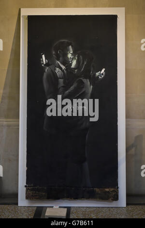 Banksy Kunstwerk 'Mobile Lovers' im Bristol Museum & Art Gallery, wo es angekündigt wird, dass das Kunstwerk verkauft wurde. Stockfoto