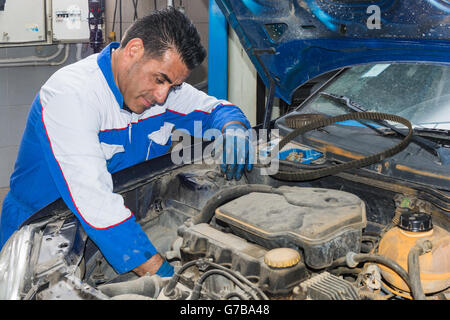 Automotive-Spezialisten einstellen eines Motors in seiner Garage, Nahaufnahme von einem erfahrenen Mechaniker Wartung eines Autos in seiner Werkstatt – Co Stockfoto