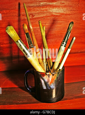 Foto von einigen schmutzigen Pinsel in einer Tasse Stockfoto