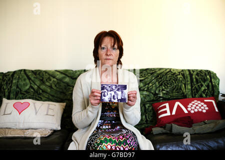 Missbrauchsuntersuchung gemäß NI. Missbrauch-Überlebende Kate Walmsley in ihrem Haus in Belfast mit einem Foto, das Kinder in einem Wohnhaus in Londonderry zeigt, mit Kate (vorne links) und Margaret McGuckian, Gründerin von Überlebenden und Opfern von institutionellem Missbrauch (zweite rechts). Stockfoto