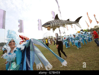 Darsteller bei der Parade in schicken Kleidern im Beestival, die im Robin Hill Adventure Park, Isle of Wight, stattfindet. Stockfoto