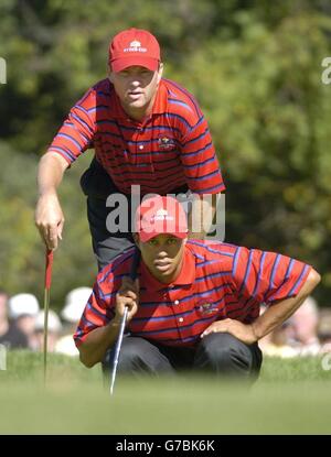 Davis Love III und Tiger Woods (unten) schauen sich ihren Putt auf dem 5. Loch während des 35. Ryder Cup im Oakland Hills Country Club, Bloomfield Township, Michigan, an. Stockfoto