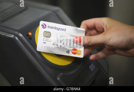 Ein Kunde an der Ticketbarriere am U-Bahnhof Canary Wharf in London, der die neue kontaktlose Bezahlung für U-Bahn, Straßenbahn, DLR London Overground und National Rail, die Oyster akzeptieren, nutzt. Stockfoto