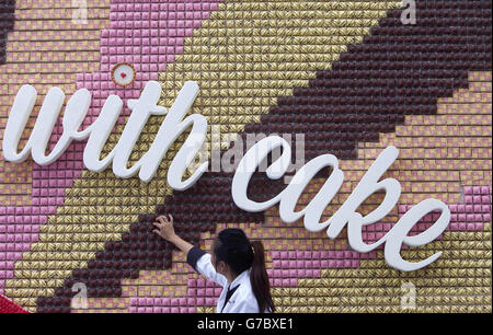 REDAKTIONELLE VERWENDUNG NUR FÜR DEN REDAKTIONELLEN GEBRAUCH die Food-Künstlerin Michelle Wibowo bringt den letzten Schliff auf ein essbares Poster von über 13,000 Mr Kipling Cakes &ETH, das im Westfield London Shopping Centre in Shepherds Bush installiert wurde. Stockfoto