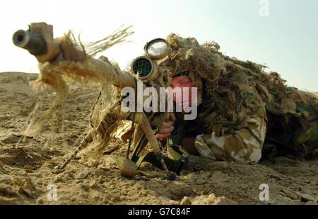 Johnathon Tointon, ein Scharfschütze vom 51 Squadron RAF Regiment aus dem RAF Lossiemouth in Schottland, nimmt bei einer frühen Patrouille am Flussufer am Stadtrand von Basra Position ein. Das Geschwader ist dafür verantwortlich, den Flughafen Basra vor einem Angriff zu schützen. Stockfoto