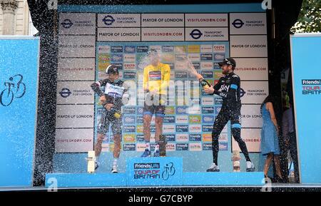 Tour of Britain 2014-Rennsieger Dylan Van Baarle von Garmin-Sharp (Mitte) sprüht Champagner neben dem zweitplatzierten Michal Kwiatkowski von Omega Pharma-Quickstep (links) und dem drittplatzierten Sir Bradley Wiggins vom Team Sky (rechts) nach der 8. Etappe der Tour of Britain 2014 in London. Stockfoto