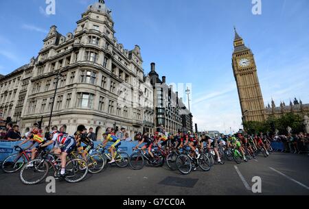 Das Hauptfeld macht sich auf der letzten Etappe der Britain Tour 2014 in London an den Houses of Parliament und Big Ben vorbei. Stockfoto