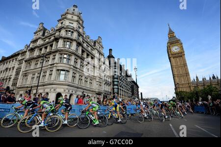 Das Hauptfeld macht sich auf der letzten Etappe der Britain Tour 2014 in London an den Houses of Parliament und Big Ben vorbei. Stockfoto