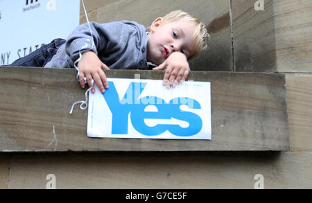 Ein Kind spielt mit einem Schild während einer Yes-Wahlkampfveranstaltung vor der Glasgow Concert Hall vor dem schottischen Unabhängigkeitsreferendum, das morgen stattfindet. Stockfoto