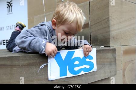 Ein Kind spielt mit einem Schild während einer Yes-Wahlkampfveranstaltung vor der Glasgow Concert Hall vor dem schottischen Unabhängigkeitsreferendum, das morgen stattfindet. Stockfoto