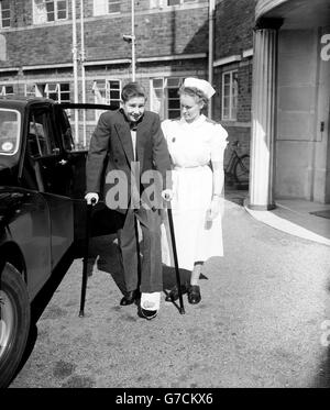 Der Jockey Lester Piggott verlässt das Queen Victoria Hospital mit dem Helfer von Krankenschwester A. Steel auf Krücken, nachdem er bei einem Sturz im Lingfield Park sein Bein gebrochen hat. Stockfoto