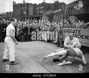 Eine Wrestling-Demonstration von Primo Carnera (mit der Kamera), dem ehemaligen Schwergewicht-Boxweltmeister, bietet Londonern in Ludgate Gardens eine ungewöhnliche Mittagszeit-Abwechslung. Carnera, 180 cm (tatsächliche Höhe war 180 cm 5 1/2), 20 Stein 'Ambling Alp', ist jetzt ein professioneller Wrestler. Stockfoto