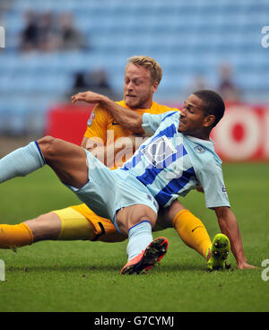 Simeon Jackson von Coventry City (rechts) und der Kapitän von Preston North End Tom Clarke Herausforderung für den Ball Stockfoto