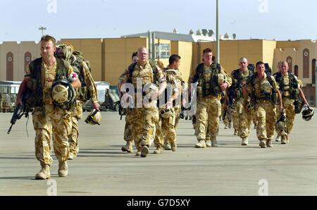 Sanitäter begleiten Soldaten von der Black Watch entlang der Start- und Landebahn des Flughafens zu einem Hercules C-130 am Basra International Airport. Die Kampfgruppe der Black Watch mit Anhängen von 40 königlichen Kommandomarinen, der Dragoon Guards der B-Squadron Queen und Unterstützung anderer Einheiten wird in dem Gebiet tätig sein, in dem die US 24 Marine Expeditionary Unit eingesetzt wurde. Stockfoto