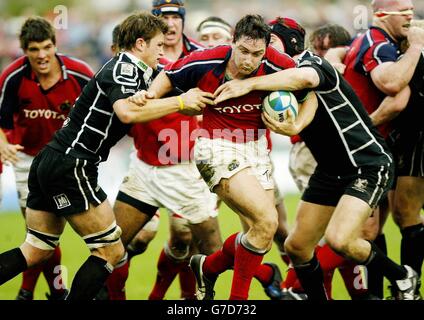 Munsters David Wallace durchbricht die Tackles von James Bater (links) und Ryan Jones (rechts) der Ospreys während des 20-18-Sieges des Heineken Cup-Spiels bei Knoll, Neath. Stockfoto