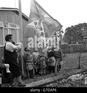 Tibetische Kinder schauen auf die Flagge ihres Landes, während sie vor dem Tibetischen Haus im britischen Pestalozzi-Kinderdorf in Sedlescombe, in der Nähe von Battle, Sussex, angehoben wird. Die Jugendlichen, die bis vor kurzem in einem Flüchtlingslager in der Nähe von Delhi untergebracht waren, gehören zu einer Gruppe von Kindern, die vom Dalai Lama vorgeschlagen wurden, nach Großbritannien zu kommen, in der Hoffnung, dass sie als Ärzte, Krankenschwestern, Lehrer und Verwalter in ihr eigenes Land zurückkehren können. Stockfoto