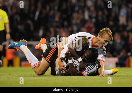 Fulhams Lasse Vigen Christensen (links unten) feiert mit Hugo Rodellega (rechts unten) und Dan Burn (oben), nachdem er gegen Bolton Wanderers das dritte Tor des Spiels erzielt hatte. Stockfoto