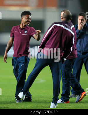 Der englische Wayne Rooney (hinten), Fabian Delph (Mitte) und Raheem Sterling (links) teilen sich einen Witz auf dem Spielfeld während eines Stadionbesuchs in der A. Le Coq Arena, Tallinn. Stockfoto