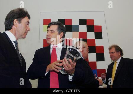 Der Schatzkanzler Gordon Brown hält den neuen Queen's Award for Enterprise, während er mit dem Generaldirektor des Institute of Directors, Miles Templeman (links), im Finanzministerium im Zentrum von London spricht. Wie der Generaldirektor der britischen Industrie, Digby Jones (rechts), und der britische Vhambers of Commerce-Vizepräsident Bill Midgely miteinander chatten. Die vier Männer forderten heute die endgültigen Nominierungen für den neuen Royal Award für Menschen, die herausragende Beiträge zur Unternehmensförderung leisten. Stockfoto