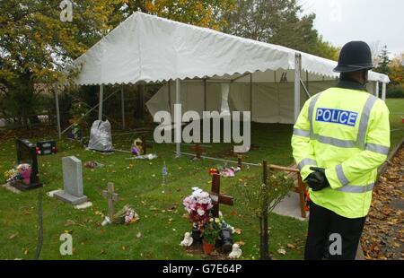 Die Polizeibeamten von Wiltshire stehen auf dem Mayshill-Friedhof in Nibley, Nr Yate in South Gloucestershire, als ein Marquee aufgesetzt wird. Das Grab eines 44-jährigen Mannes soll nach seiner Beerdigung vor vier Monaten exhumiert werden, nachdem „bisher unbekannte Informationen“ ans Licht gekommen sind. Stockfoto