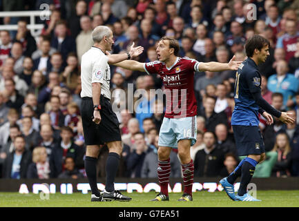 Schiedsrichter Martin Atkinson (links) gibt eine Entscheidung, die angers West Ham United's Mark Noble (rechts) während der Barclays Premier League Spiel in Upton Park, London. Stockfoto