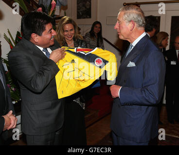 Der Prinz von Wales wird bei einem Empfang in der Residenz des Botschafters in Bogota, Kolumbien, mit einem kolumbianischen Fußballtrikot überreicht. Stockfoto