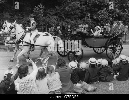 Königin Elizabeth II. Und Prinz Philip reiten in ihrer Pferdekutsche an Schulkindern vorbei auf dem Weg zum Kurs in Royal Ascot. Stockfoto