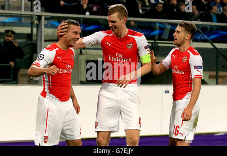 *Alternate Crop* Arsenals Lukas Podolski (links) feiert das Scoring seiner Seite Zweites Tor des Spiels mit Teamkollegen pro Mertesacker (Mitte) Und Aaron Ramsey (rechts) Stockfoto