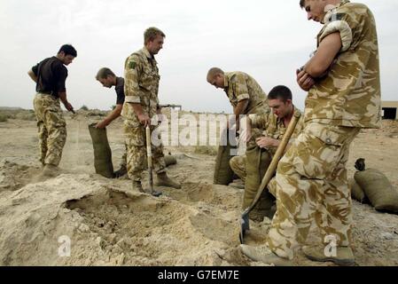 NUR FÜR ÜBERSEE: Marineinfanteristen aus dem Jahr 40, die an die Kampfgruppe der Black Watch angeschlossen sind, füllen Sandsäcke auf einer vorwärts operierenden Basis in der Nähe der Camp Dogwood-Basis, von wo aus sie die Bewegungen zur umkämpften Stadt Fallujah überwachen. Stockfoto