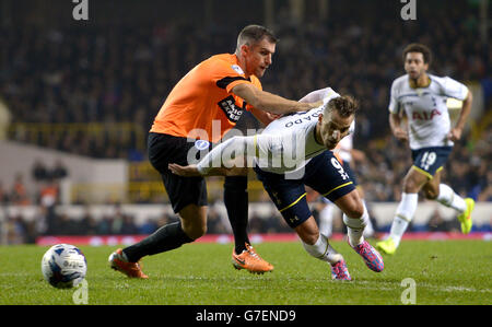 Roberto Soldado von Tottenham Hotspur (rechts) und Aaron Hughes von Brighton und Hove Albion (links) kämpfen während des Spiels der vierten Runde des Capital One Cup in der White Hart Lane, London, um den Ball. Stockfoto