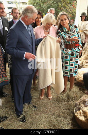 Der Prinz von Wales und die Herzogin von Cornwall werden mit einem traditionellen Wollumhang während einer Tour zu einer Bio- und Urban Sustainability Fair in der Residenz des britischen Botschafters in Bogota, Kolumbien, Am zweiten Tag der Reise des Prinzen von Wales und der Herzogin von Cornwall nach Kolumbien und Mexiko. Stockfoto