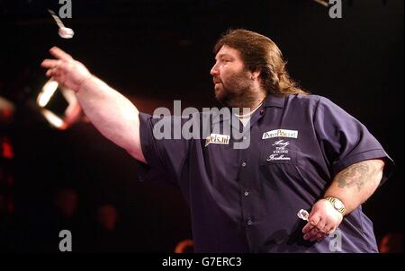 Andy Fordham startet seinen DART während des Kopf-an-Kopf-Showdowns gegen Phil 'The Power' Taylor im Circus Tavern, Purfleet. Fordham hat den Nachteil, mit einem gebrochenen Handgelenk zu spielen. Stockfoto