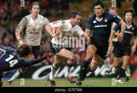 Die walesische Scrum Half Gareth Cooper durchbricht die japanischen Koichiro Kubota (links) und Takanori Kumagae, um beim Spiel der Lloyds TSB Autumn Series im Millennium Stadium in Cardiff zu Punkten. Stockfoto