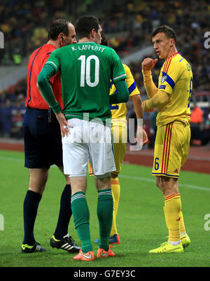 Kyle Lafferty (links) aus Nordirland argumentiert mit Vlad Chiriches aus Rumänien während der UEFA-EM 2016-Qualifikation in der Arena Nationala, Bukarest. Stockfoto