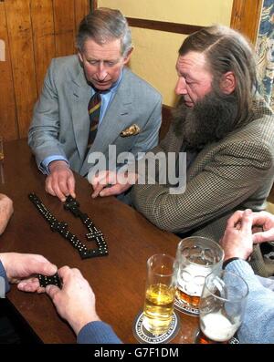 Der Prinz von Wales spielt während seines Besuchs im Dorf Dominos im Farmers Arms Pub in Muker, Swaledale. Stockfoto