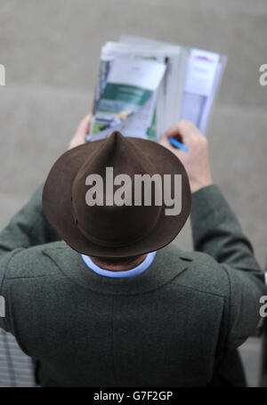 Ein Rennfahrer überprüft die Chancen am zweiten Tag des Showcase-Meetings 2014 auf der Cheltenham Racecourse, Cheltenham. Stockfoto