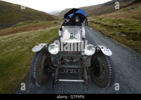 Christopher und Rachael Williams mit dem Riley Special 1930, während Oldtimer den legendären Lakeland-Berg erklimmen, sich über 2,100 Meter auf einer der steilsten Straßen Englands schlängeln und bei der spektakulären Motorsportveranstaltung an der Honister Slate Mine in Cumbria vorbeifahren. Stockfoto