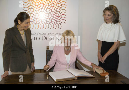 Die Herzogin von Cornwall (Mitte) signiert das Gästebuch, während die First Lady Marcia Santos bei einem Besuch der Escuela de Artes Y Oficioss, Kunstgewerbeschule in Bogota, Kolumbien, aufschaut. Stockfoto