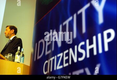 Innenminister David Blunkett spricht auf einer Konferenz, die vom Think-Tank Institute for Public Policy Research über die Zukunft seiner Multimilliarden Pfund-ID-Karten-Projektkarten in einem zentralen Londoner Veranstaltungsort organisiert wird. Als Herr Blunkett ankam, verbrannten Demonstranten von NO2ID riesige Nachstellungen von Ausweisen mit den Gesichtern des britischen Premierministers Tony Blair und Herrn Blunkett. Stockfoto