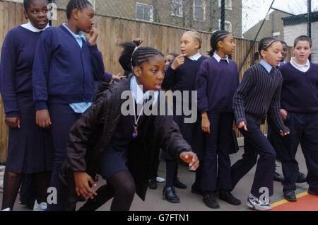 Roshana Roberts (Mitte-links), 10, bereitet sich auf die Teilnahme an einem Staffellauf-Sprint-Rennen vor, das von der Lehrerin Michelle Akinyemi (nicht abgebildet) an der Stockwell Primary School im Süden Londons organisiert wird. Die Schule hat im vergangenen Jahr eine verbesserte Leistung der Grundschule erreicht, was einer nationalen Verbesserung in den Grundschulen nach der Veröffentlichung der diesjährigen Leistungs- und Leistungstabellen entspricht. Stockfoto