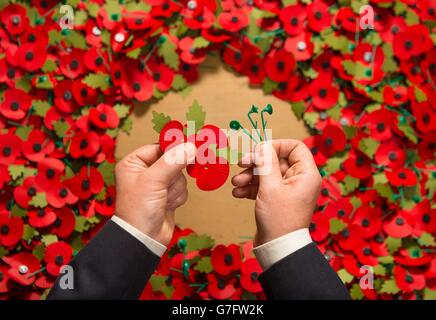 Armeeveteran Shane Crowhurst stellt beim Royal British Legion Poppy Appeal in Aylesford, Kent, einen Papiermohn zusammen, der zu den Tausenden von Papiermohn gehört, der dieses Jahr durch Sainsbury's after Armistice Day recycelt wird. Stockfoto