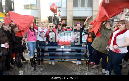 Mitglieder der Familie von Rik Mayall (links) sehen sich als Bank an, um das Leben zu feiern, das Rik Mayall von Fans an dem Ort enthüllt wird, an dem die unteren Abspann in der Queen Caroline Street, Hammersmith, London, gedreht wurden. Stockfoto