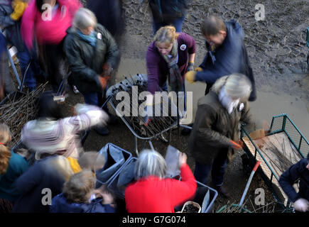 DIE REDAKTION BEMERKT, DASS FREIWILLIGE MIT LANGER VERSCHLUSSZEIT dabei helfen, die Keramikmohn bei der Installation Blood Swept Lands und Seas of Red im Tower of London zu demontieren. Stockfoto