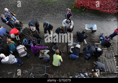 Freiwillige helfen, die Keramikmohn an der Blood Swept Lands und Seas of Red Installation im Tower of London zu demontieren. Stockfoto