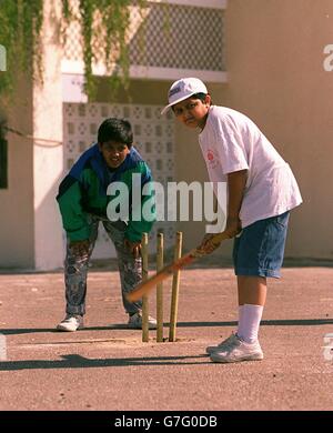 Kinder spielen Sport in Dubai, Vereinigte Arabische Emirate. Jungs spielen Cricket in den Straßen von Dubai Stockfoto